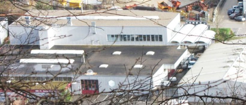 Auf diesem Bild sehen Sie den Produktionsstandort der ISBA AG in Zwingen. Ersichtlich sind die Produktionshalle für Oblichter bzw. Lichtkuppeln, das Lager( Flachdachfenster, Glas-Oberlichter, GFK-Deckel ) und die Halle für die Produktion von kundenspezifischen Acryl-Glas-Abdeckungen.
