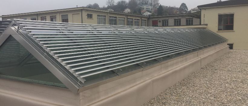 Voûtes translucides avec brise soleil - les stores servant à empêcher la pièce de se réchauffer durant les périodes chaudes. Equipés d'entraînements électriques, ils assurent un climat agréable selon les conditions météorologiques.